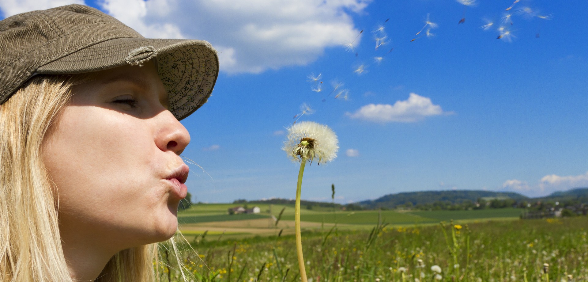Junge Frau mit Pusteblume (© Martin Oss – stock.adobe.com)